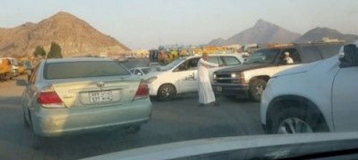 رجل ستيني يقوم بتنظيم حركة السيارات بنفسه وسط زحام شديد في مكة